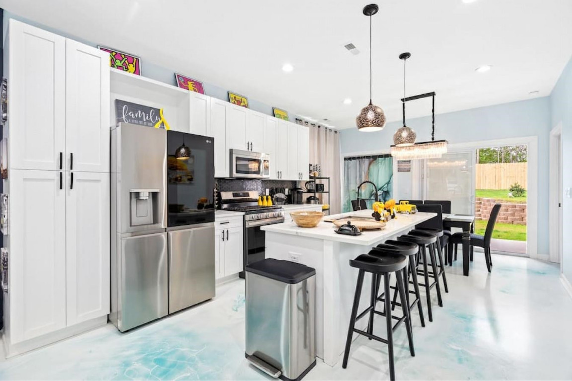 6901 Jeffreys Creek Lane Raleigh, NC 27616 - Photo 3 of 37 a kitchen with stainless steel appliances kitchen island a table chairs refrigerator and microwave