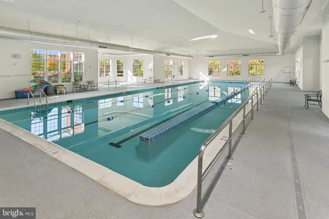 a dining room with furniture a large window and a chandelier