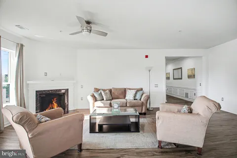 a kitchen with stainless steel appliances a refrigerator a stove a sink dishwasher and white cabinets with wooden floor