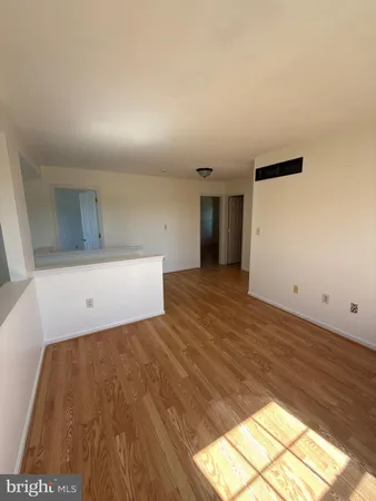a view of a room with wooden floor and an entryway