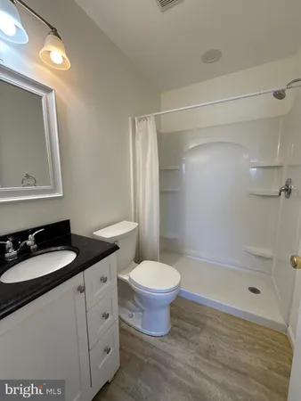 a bathroom with a granite countertop sink toilet and shower