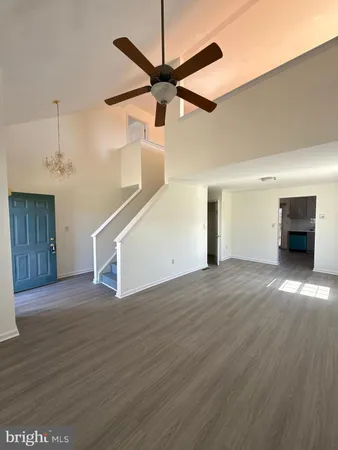 a view of empty room with wooden floor and window
