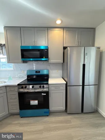 a kitchen with a stove a refrigerator and a microwave