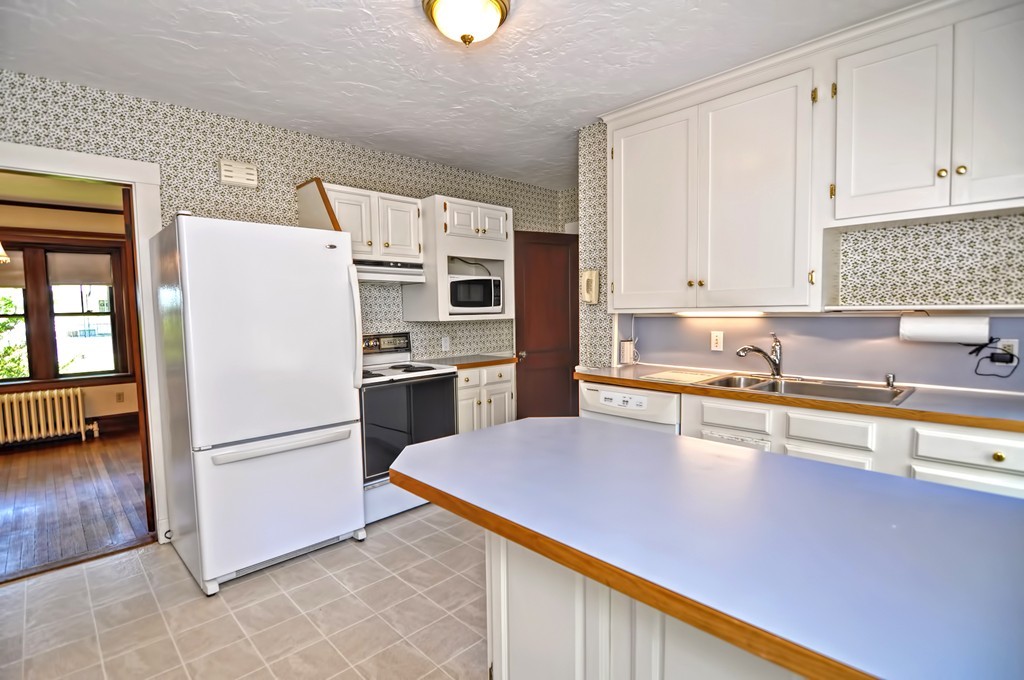 175 Union Street Walpole, MA 02032 - Photo 6 of 29 a kitchen with granite countertop a refrigerator a sink a stove a microwave and island
