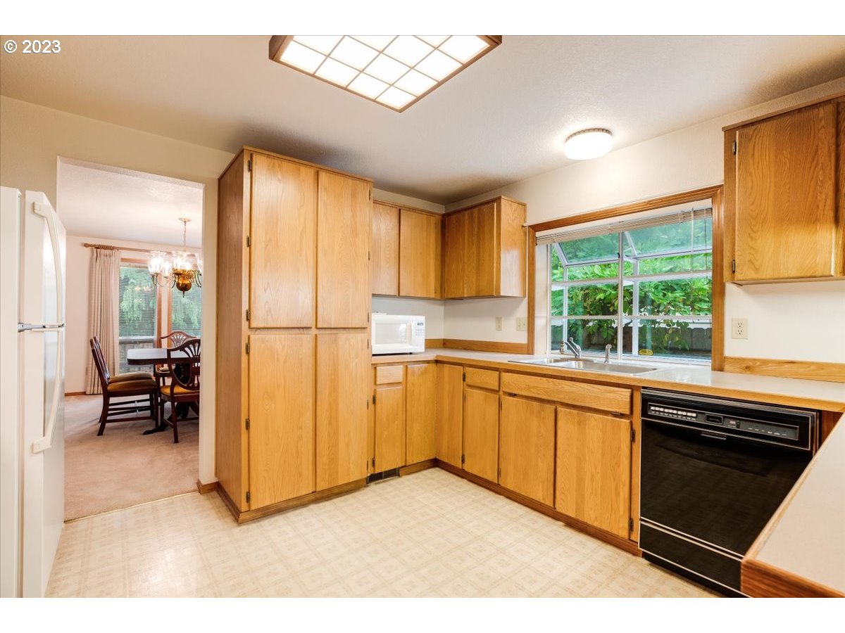1502 Southeast Elliott Avenue Gresham, OR 97080 - Photo 14 of 37 a kitchen with stainless steel appliances granite countertop a refrigerator a sink dishwasher a stove and white cabinets with wooden floor