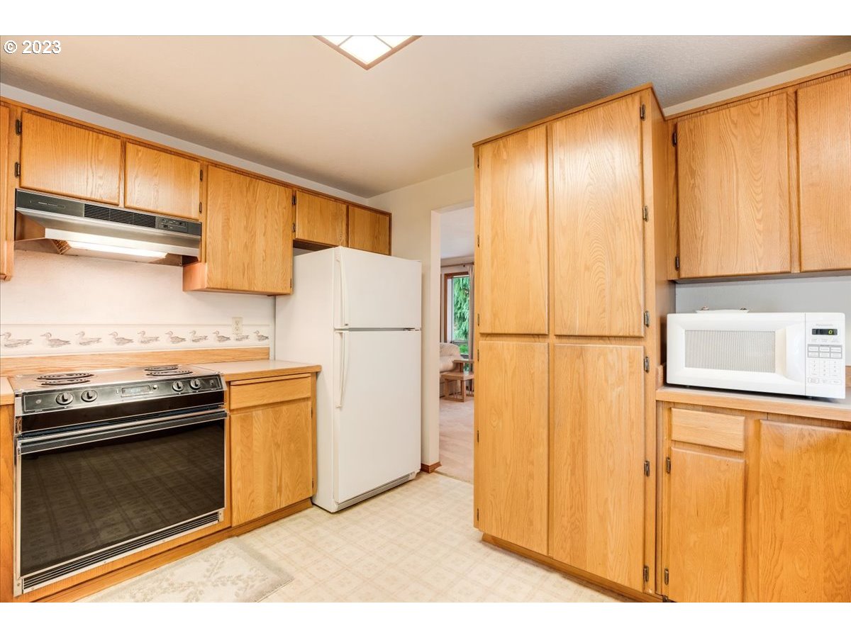 1502 Southeast Elliott Avenue Gresham, OR 97080 - Photo 16 of 37 a kitchen with cabinets a refrigerator and a sink