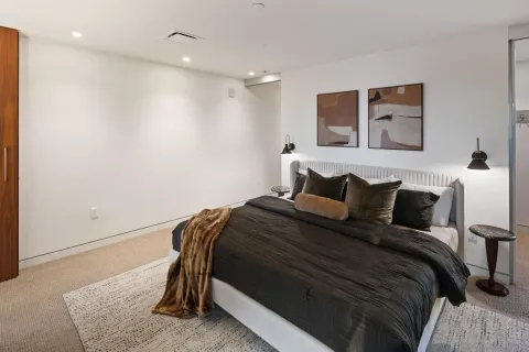 a bedroom with a bed and a potted plant