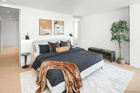 a bedroom with a bed and a potted plant