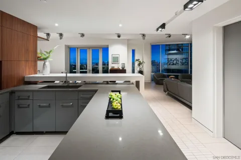 a kitchen with kitchen island granite countertop a sink counter top space a refrigerator and cabinets