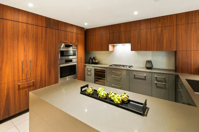 a kitchen with granite countertop a refrigerator and a stove top oven