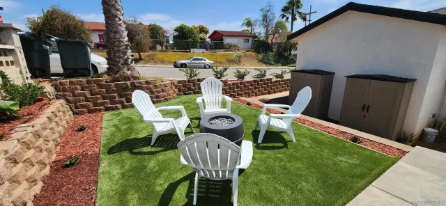 a view of an chairs and table in backyard