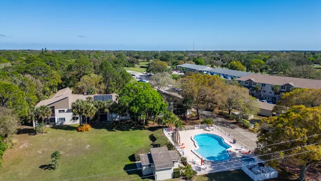 an aerial view of a house with yard swimming pool and lake view