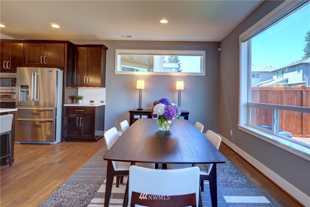 15 175th Place Southwest Bothell, WA 98012 - Photo 14 of 40 a kitchen with stainless steel appliances granite countertop a stove a refrigerator a sink a dining table and chairs with wooden floor