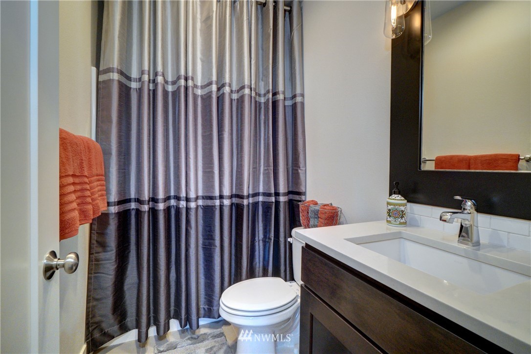 15 175th Place Southwest Bothell, WA 98012 - Photo 17 of 40 a bathroom with a sink a toilet a mirror and shower curtain