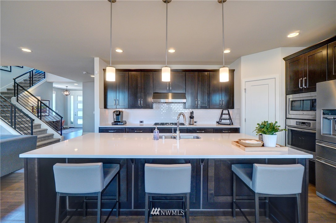 15 175th Place Southwest Bothell, WA 98012 - Photo 10 of 40 a kitchen with granite countertop a table chairs microwave and cabinets
