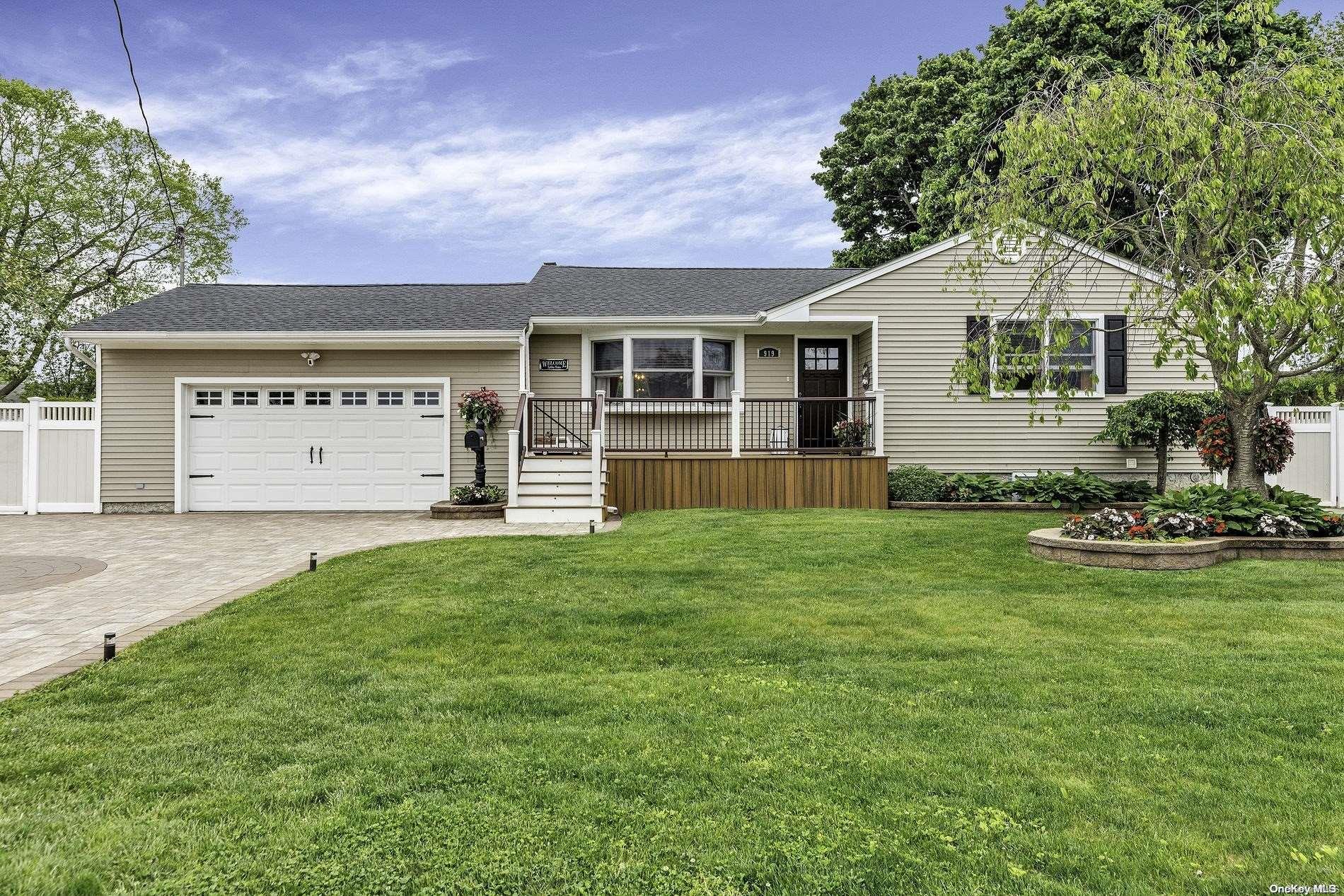 919 5th Street West Babylon, NY 11704 - Photo 1 of 1 a front view of a house with a yard and garage