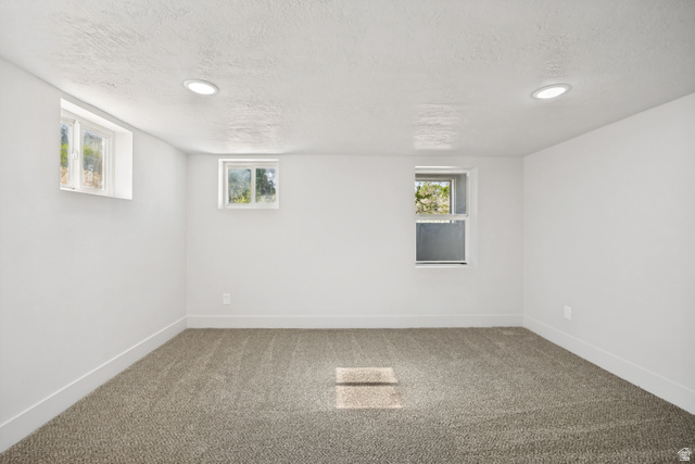 662 29th Street Ogden, UT 84403 - Photo 12 of 23 Spacious room featuring neutral carpeting, white walls, recessed ceiling lighting, and multiple windows