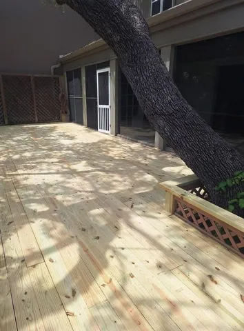 a view of an empty room with wooden floor and fence
