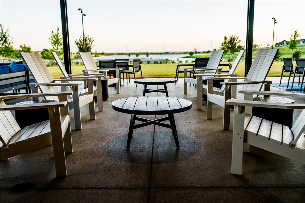 179 Summer Rain Way Rhome, TX 76078 - Photo 10 of 26 a living room with furniture a flat screen tv and a floor to ceiling window