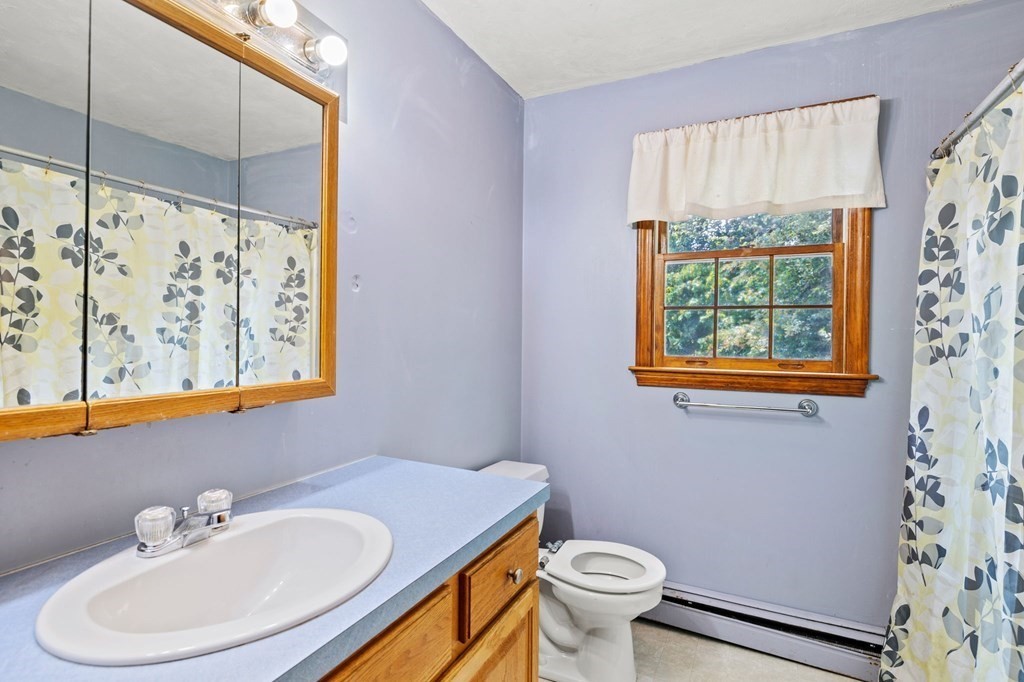 44 Smith Road Mansfield, MA 02048 - Photo 19 of 21 a bathroom with a sink a mirror a toilet and a window