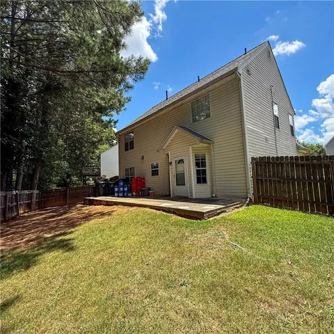 a view of a house with backyard and tree