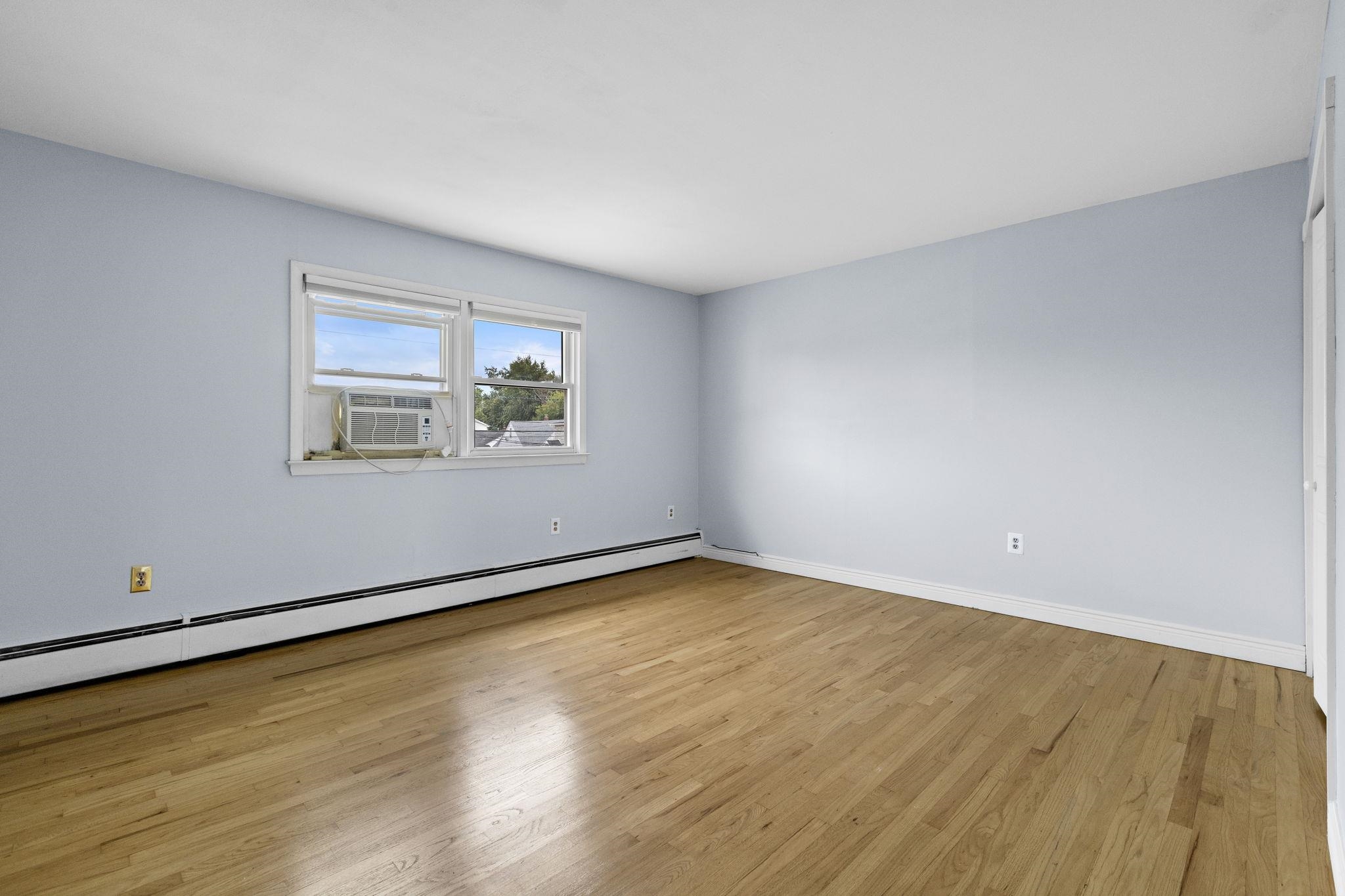 665 9th Street, Unit A Secaucus, NJ 07094 - Photo 11 of 17 an empty room with wooden floor and windows