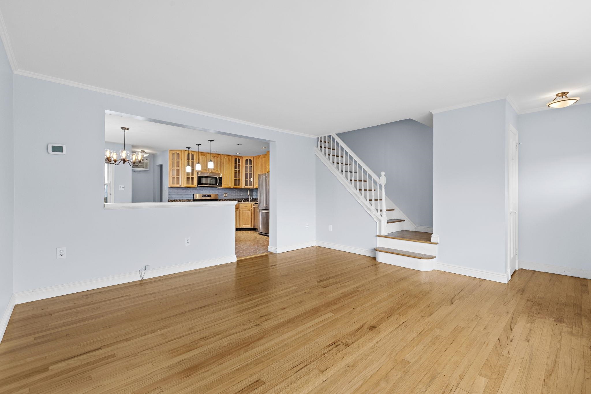 665 9th Street, Unit A Secaucus, NJ 07094 - Photo 2 of 17 a view of empty room with wooden floor and kitchen