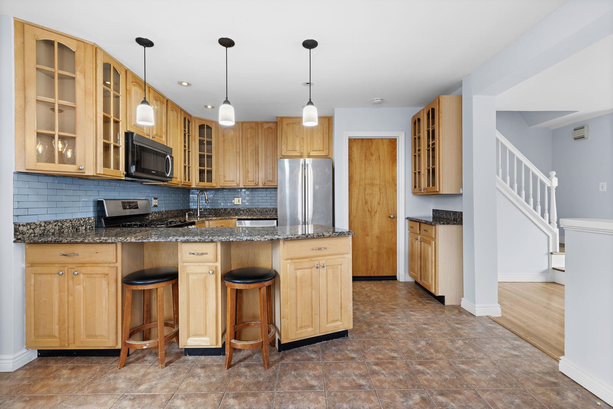 665 9th Street, Unit A Secaucus, NJ 07094 - Photo 7 of 17 a kitchen that has a lot of cabinets in it and stainless steel appliances