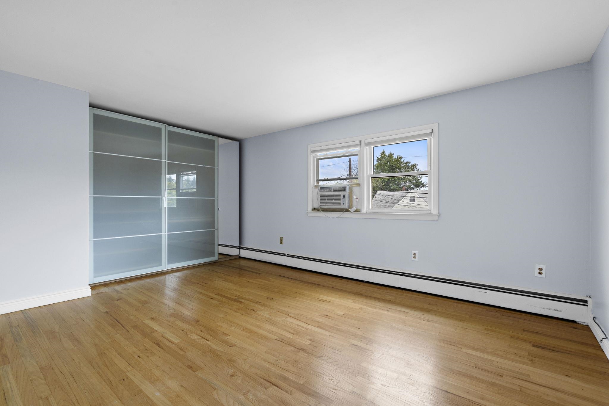 665 9th Street, Unit A Secaucus, NJ 07094 - Photo 10 of 17 an empty room with wooden floor and windows