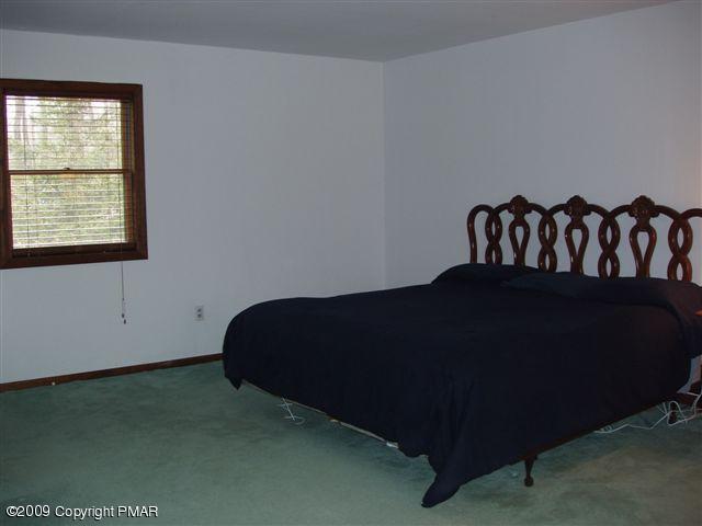 153 Little Twig Road Effort, PA 18330 - Photo 9 of 22 a black leather couch sitting in a bedroom next to a window