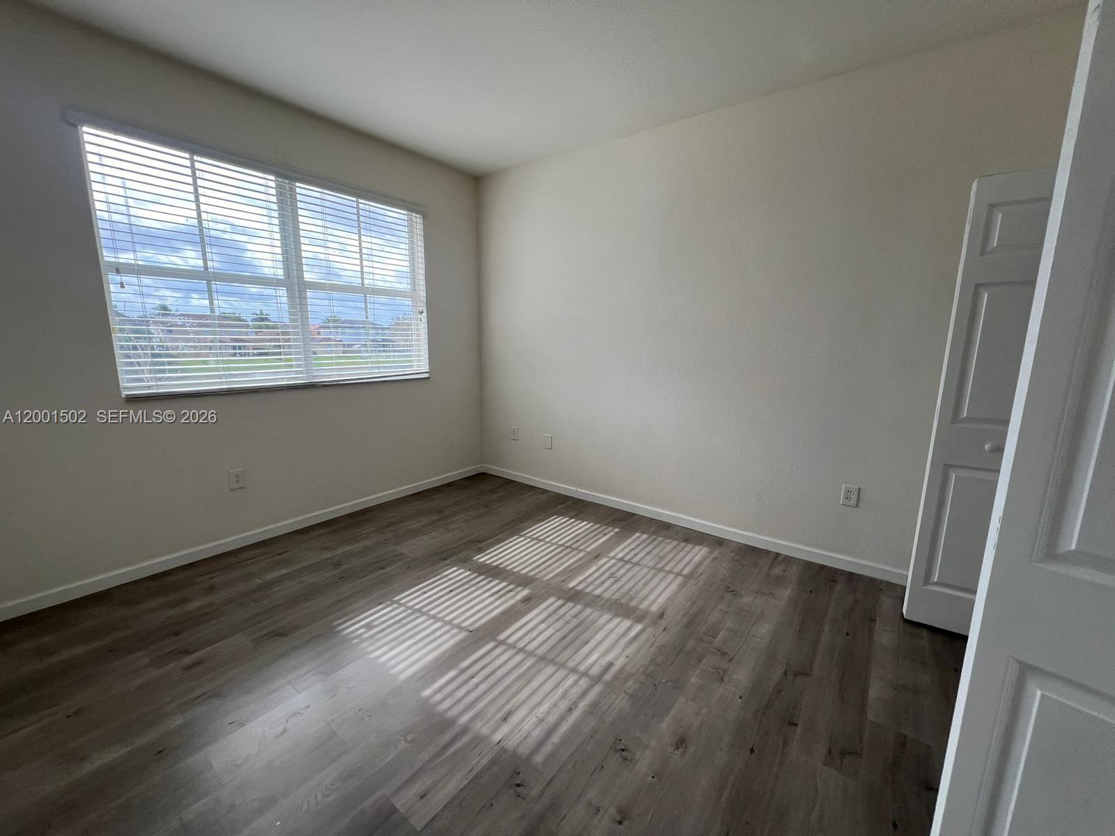 16568 Southwest 54th Street Miami, FL 33185 - Photo 15 of 30 an empty room with wooden floor and windows