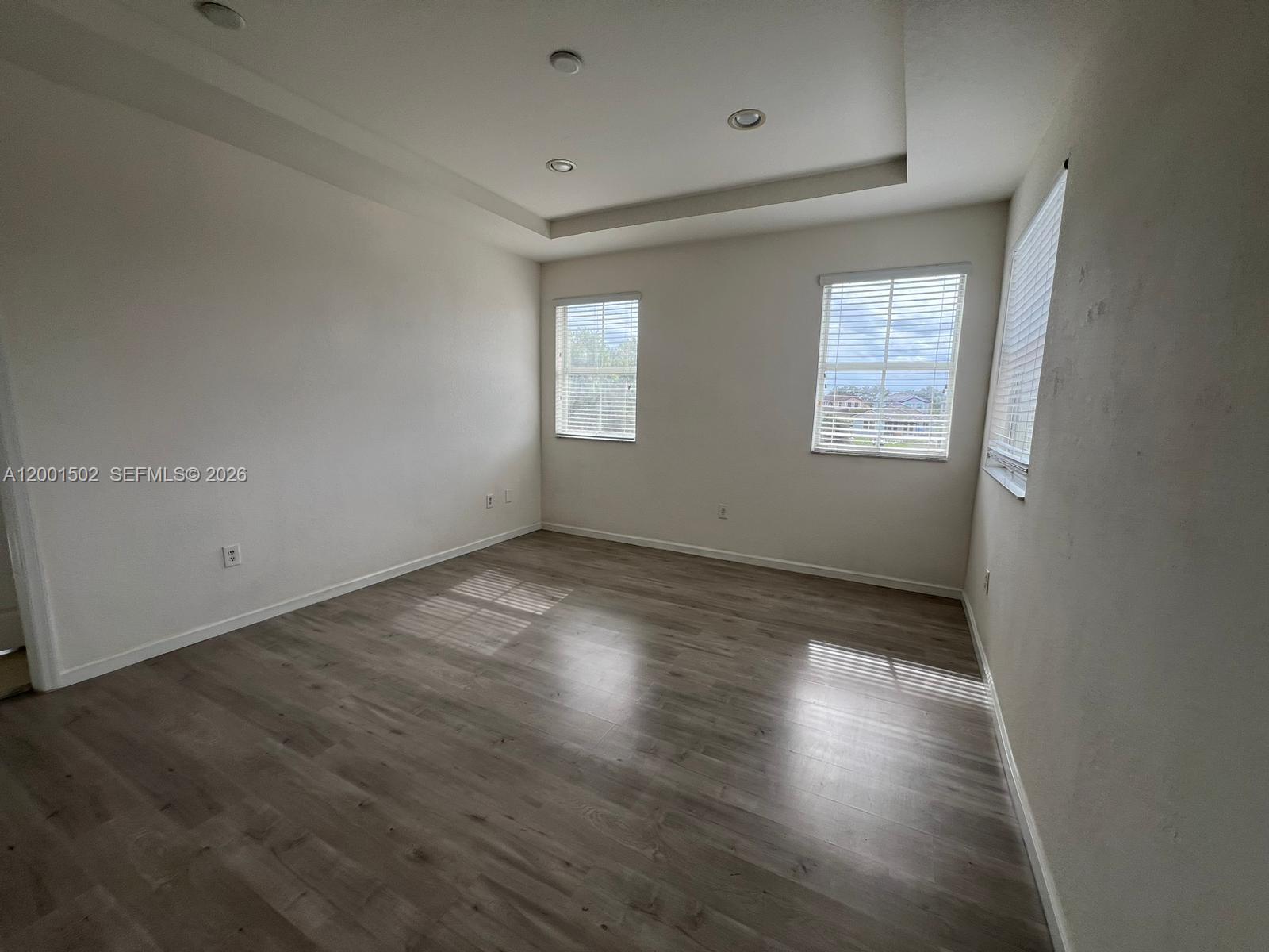 16568 Southwest 54th Street Miami, FL 33185 - Photo 16 of 30 an empty room with wooden floor and windows