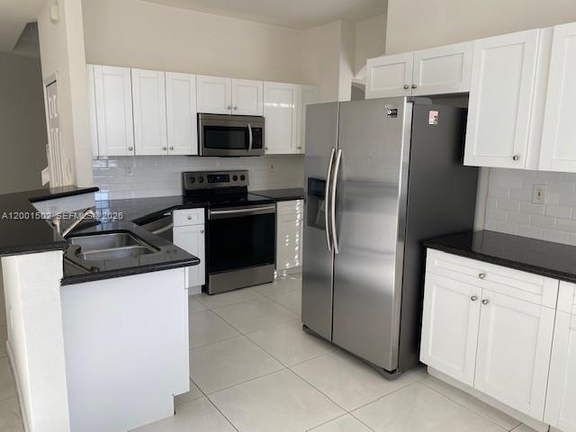 16568 Southwest 54th Street Miami, FL 33185 - Photo 18 of 30 a kitchen with stainless steel appliances granite countertop a refrigerator stove and microwave