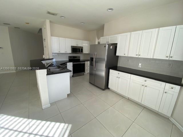 16568 Southwest 54th Street Miami, FL 33185 - Photo 4 of 30 a kitchen with stainless steel appliances a refrigerator sink and cabinets