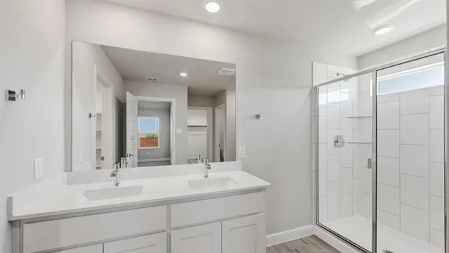an empty room with wooden floor closet and windows