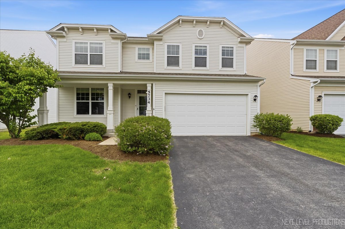 5734 Oak Ridge Way Lisle, IL 60532 - Photo 2 of 33 a front view of a house with a yard and garage