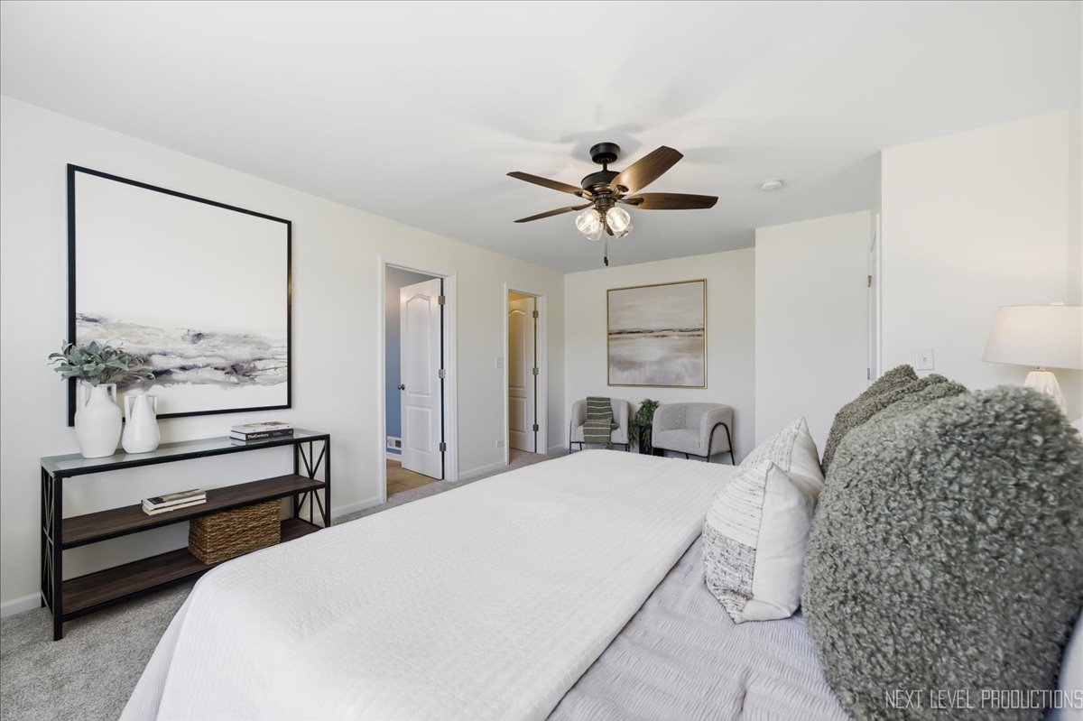 5734 Oak Ridge Way Lisle, IL 60532 - Photo 23 of 33 a spacious bedroom with a bed a chandelier and a dresser