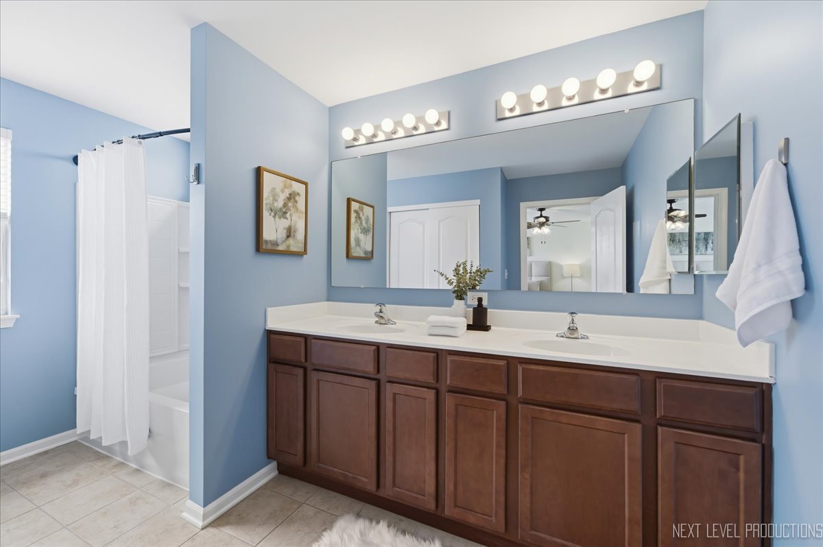 5734 Oak Ridge Way Lisle, IL 60532 - Photo 25 of 33 a bathroom with a double vanity sink and a mirror