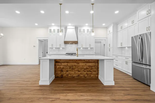 a kitchen with white cabinets and appliances