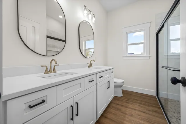 a bathroom with a sink a toilet and a mirror