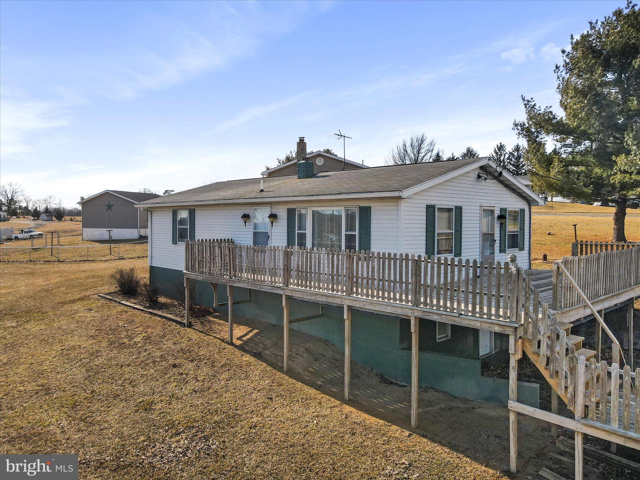 a view of a house with a wooden deck and a floor to ceiling window