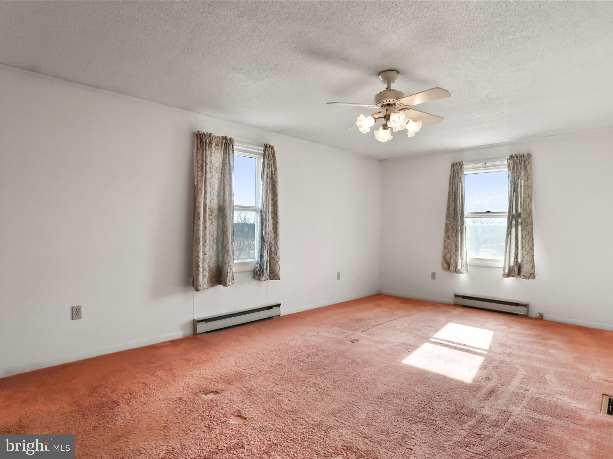101 Carvers Way Falling Waters, WV 25419 - Photo 14 of 37 an empty room with chandelier fan and windows
