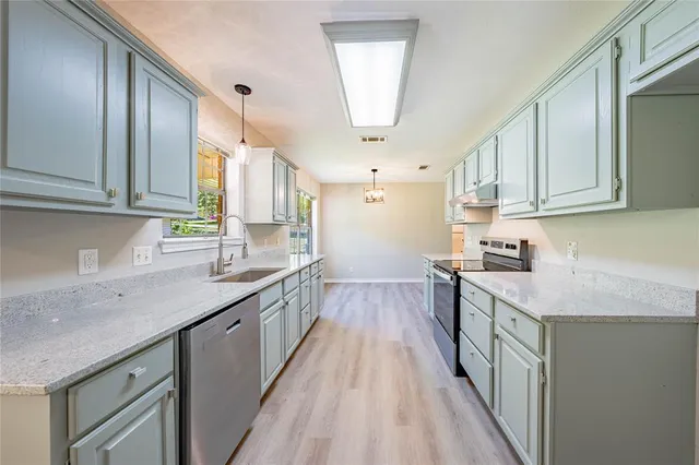 a kitchen with a sink stove and cabinets