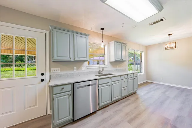 a kitchen with granite countertop a sink and cabinets with wooden floor