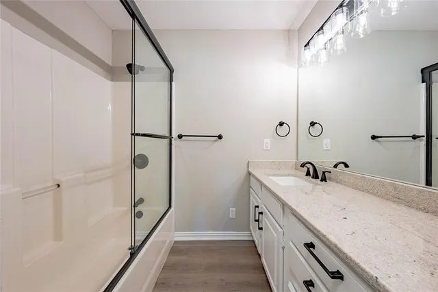 a bathroom with a double vanity sink a mirror and shower