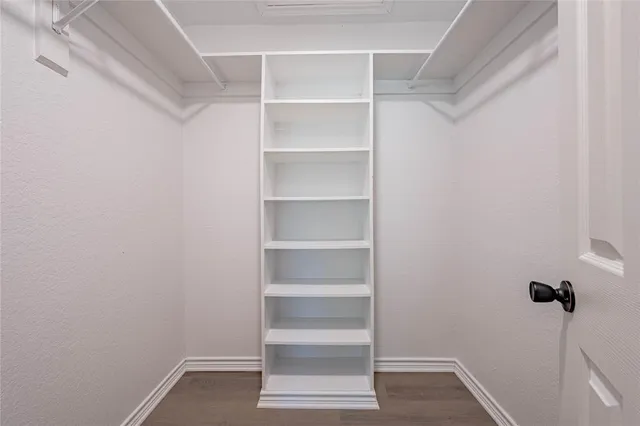 a view of walk in closet with empty racks