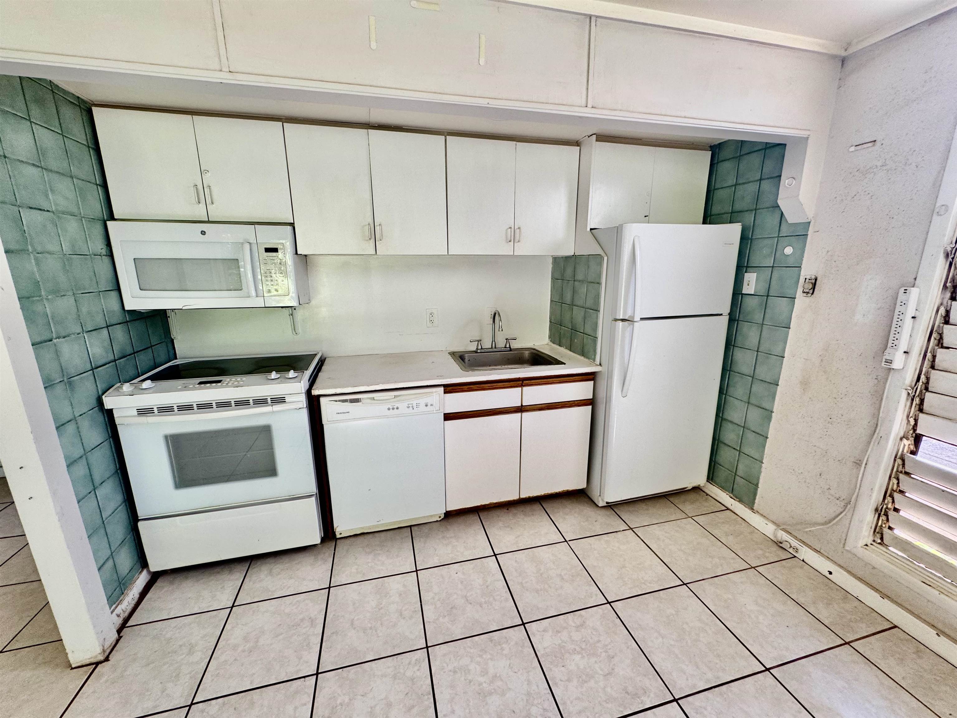 3559 Lower Honoapiilani Road, Unit 2D Lahaina, HI 96761 - Photo 3 of 16 a kitchen with a stove a sink and a refrigerator