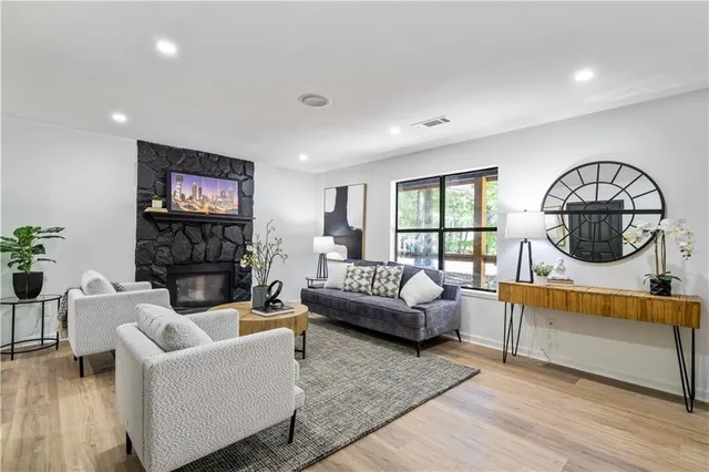 a living room with fireplace furniture and a wooden floor