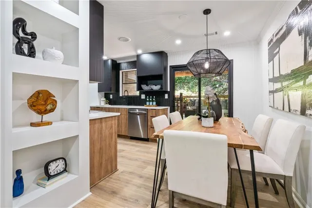a view of a dining room with furniture a chandelier and wooden floor