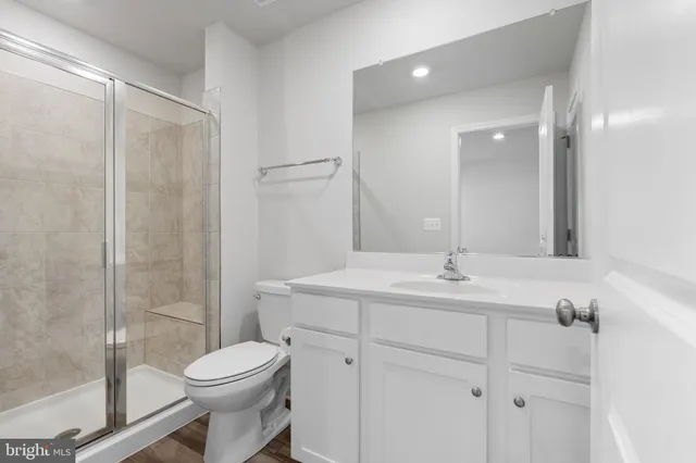 a bathroom with a toilet a sink a mirror and a shower